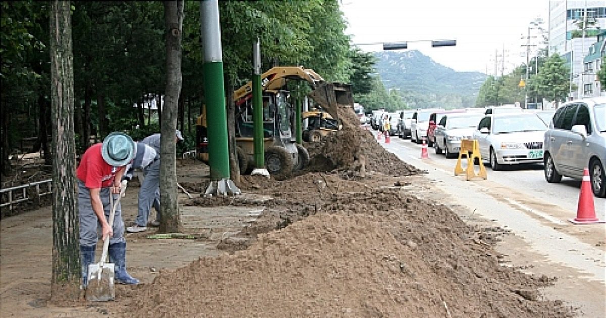 침수 후 쌓인 토사와 침수 폐기물을 제거하는 모습