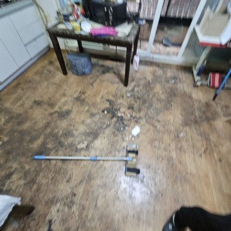 고독사 현장 바닥 오염물을 전용 도구로 제거하는 모습